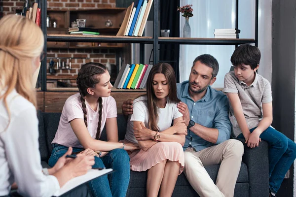 Family cheering up woman on therapy session by female counselor in office — Stock Photo