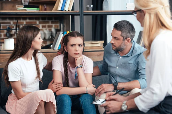 Parents cheering up daughter on therapy session by female counselor in office — Stock Photo