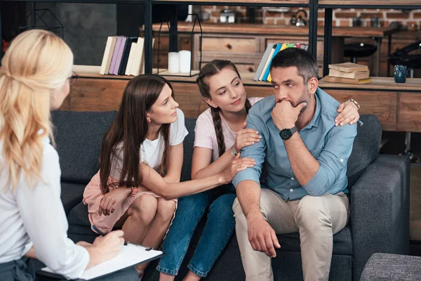 Family cheering up man on therapy session by female psychiatrist in office — Stock Photo