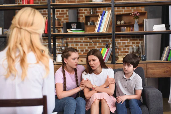 Kinder ermuntern depressive Mutter zu Familientherapie durch weibliche Beraterin — Stockfoto