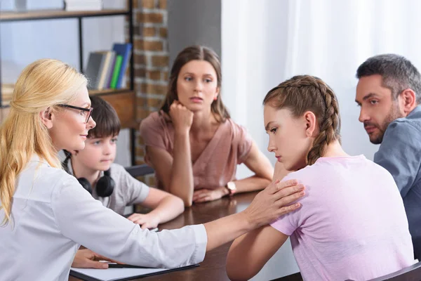 Conselheira feminina animando adolescente chateada na sessão de terapia familiar no escritório — Fotografia de Stock