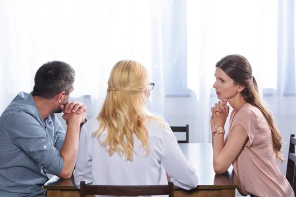 Rear view of female psychiatrist talking to couple on therapy session in office — Stock Photo