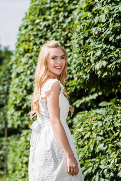 Beautiful happy young blonde woman smiling at camera outdoors — Stock Photo