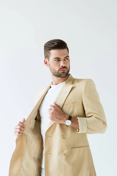 Красивий бородатий чоловік випрямляє куртку ізольовано на білому тлі — стокове фото