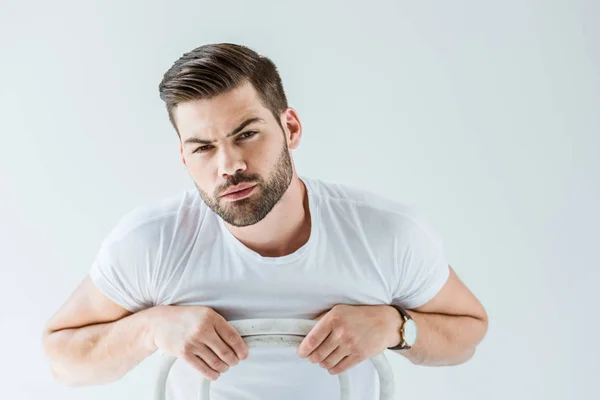 Elegante joven con camisa blanca sentado en silla aislado sobre fondo blanco - foto de stock