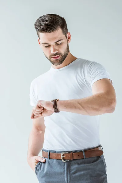 Modisch selbstbewusster Mann, der seine Uhr isoliert auf weißem Hintergrund überprüft — Stockfoto