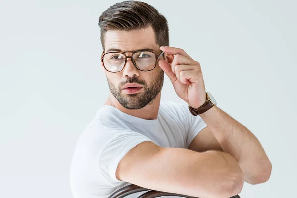 Homem confiante na moda fixando seus óculos isolados no fundo branco — Fotografia de Stock