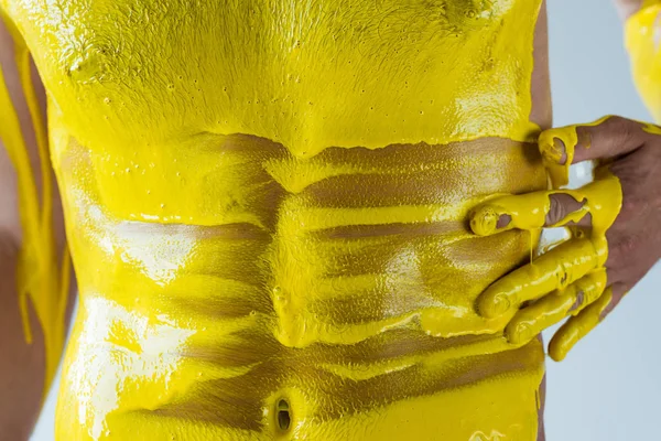 Vue recadrée du torse mâle dans un liquide jaune isolé sur fond blanc — Photo de stock