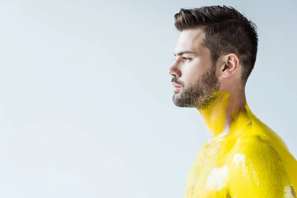 Joven con cuerpo pintado de amarillo aislado sobre fondo blanco - foto de stock