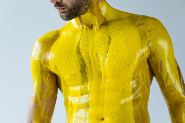 Красивый бородатый мужчина с туловищем, покрытым желтой краской на белом фоне — стоковое фото