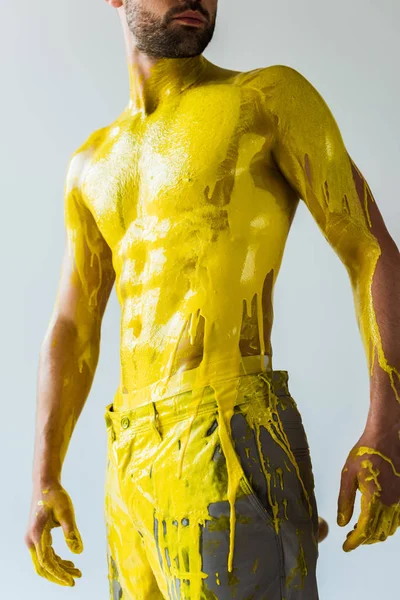 Corps masculin musclé recouvert de peinture jaune isolé sur fond blanc — Photo de stock