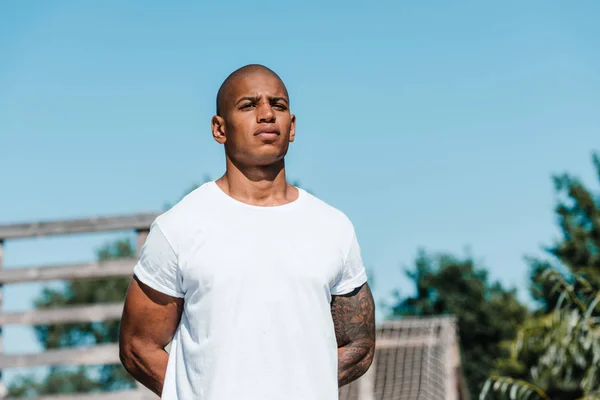 Portrait of african american tattooed soldier in white shirt standing on range — Stock Photo