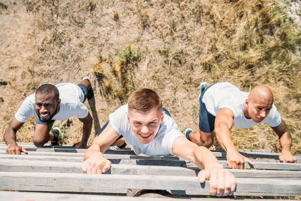 Overhead view of multiethnic soldiers practicing in obstacle run on range — Stock Photo