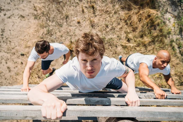 Overhead view of multiethnic soldiers practicing in obstacle run on range — Stock Photo