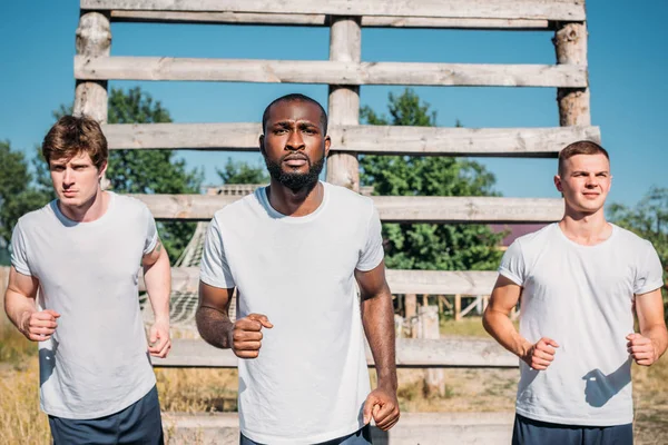 Portrait of multicultural soldiers practicing in obstacle run on range — Stock Photo