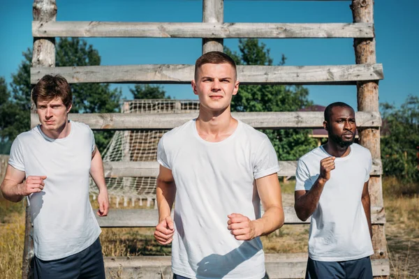 Portrait of multicultural soldiers practicing in obstacle run on range — Stock Photo