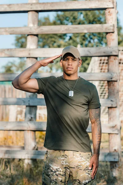 Ritratto di soldato afroamericano fiducioso in berretto con tag dog a portata di mano — Foto stock