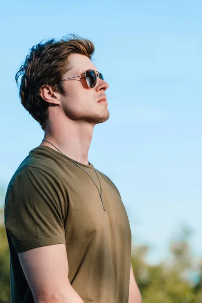 Seitenansicht eines selbstbewussten Soldaten mit Sonnenbrille vor blauem Himmel — Stockfoto