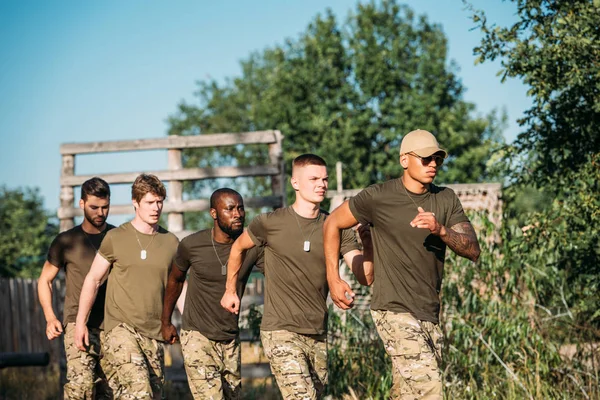 Soldados multiétnicos em uniforme militar correndo ao alcance — Fotografia de Stock