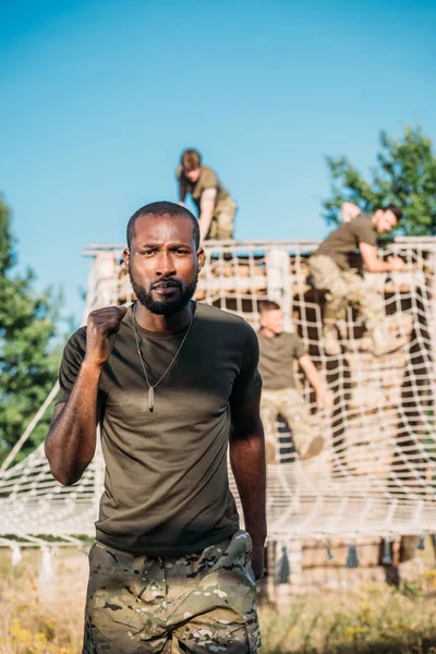 La concentration sélective des soldats multiethniques pratiquant dans les obstacles à portée de tir ; — Photo de stock