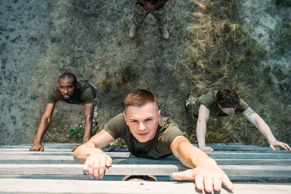 Overhead view of multiethnic soldiers practicing in obstacle run on range — Stock Photo