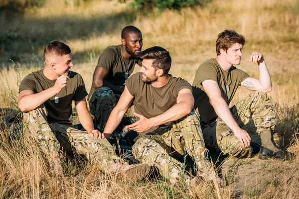 Multiracial young soldiers in military uniform resting on range — Stock Photo