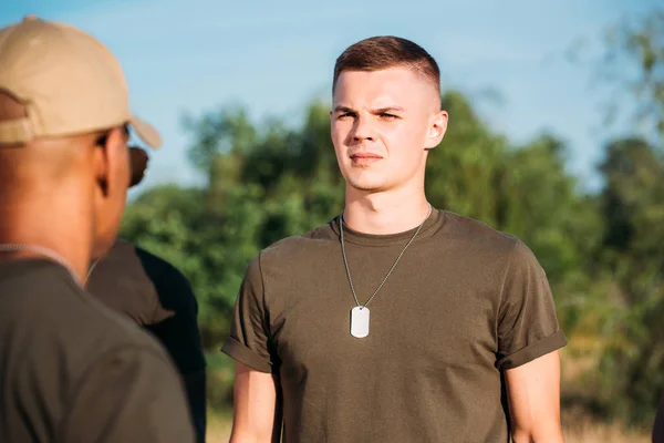 Selective focus of young soldier with tag dog on range — Stock Photo