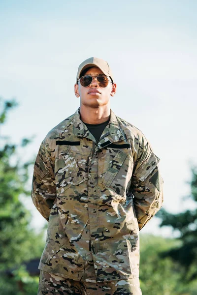 Retrato de soldado afroamericano en uniforme militar, gorra y gafas de sol - foto de stock