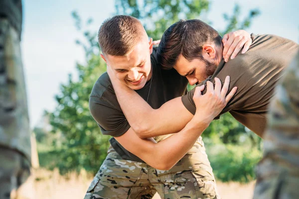 Foco seletivo de jovens soldados praticando luta corpo a corpo no alcance — Fotografia de Stock