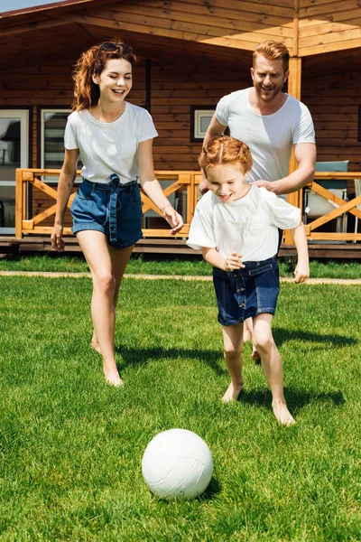 Bella giovane famiglia che gioca a calcio in giardino — Foto stock