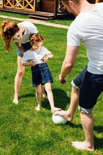 Happy young family playing football on garden — Stock Photo