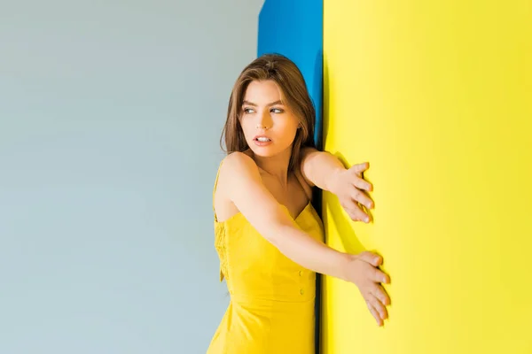 Femme mannequin debout par fond bleu et jaune — Photo de stock
