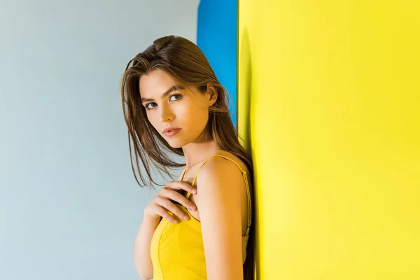 Модель жіночої моди в жовтому одязі на синьо-жовтому тлі — стокове фото