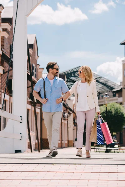 Couple walking together on street after shopping — Stock Photo