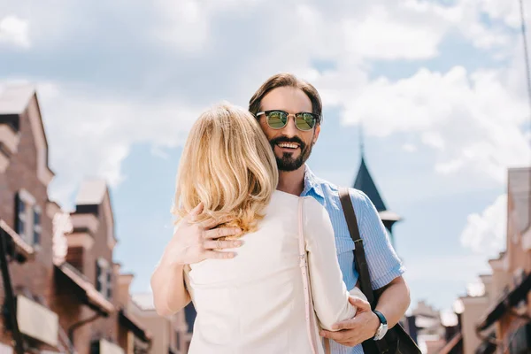 Sorridente coppia adulta che si abbraccia per strada — Foto stock