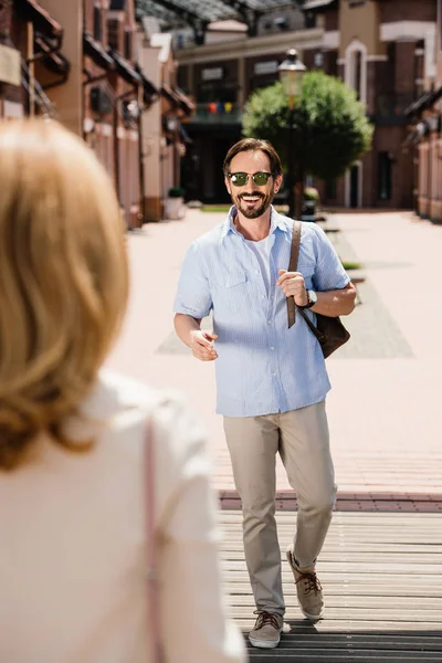 Happy adult couple meeting on street in city — Stock Photo