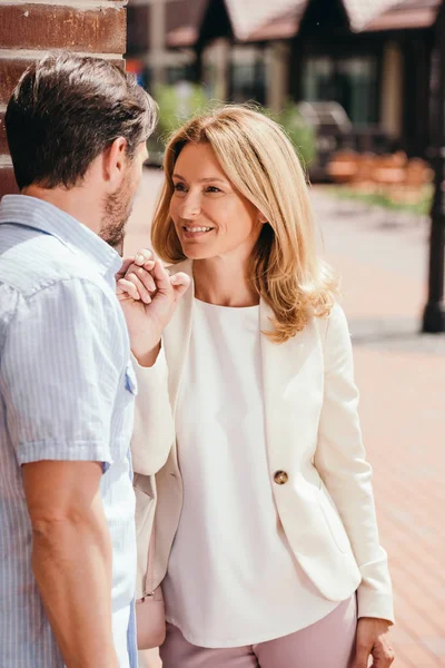 Affectionate couple holding hands and looking at each other on street — Stock Photo