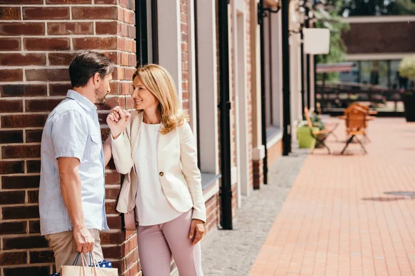Affectionate couple holding hands and looking at each other on street in city — Stock Photo
