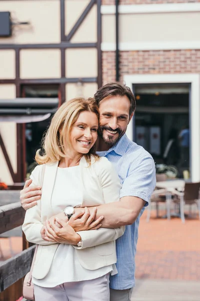 Smiling couple cuddling on bridge in city — Stock Photo