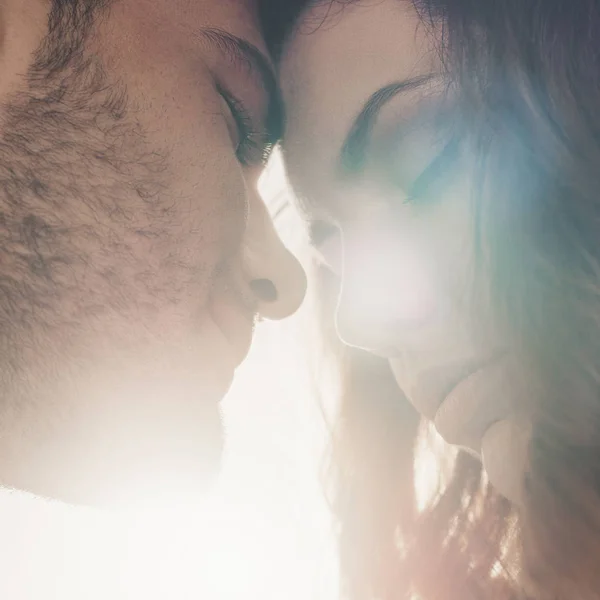 Close up shot of sensual couple in love leaning head to head in front on sunlight — Stock Photo