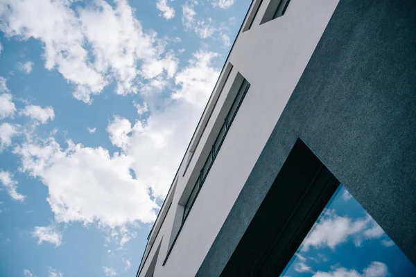 Vista de ángulo bajo del edificio contra el cielo azul brillante nublado - foto de stock