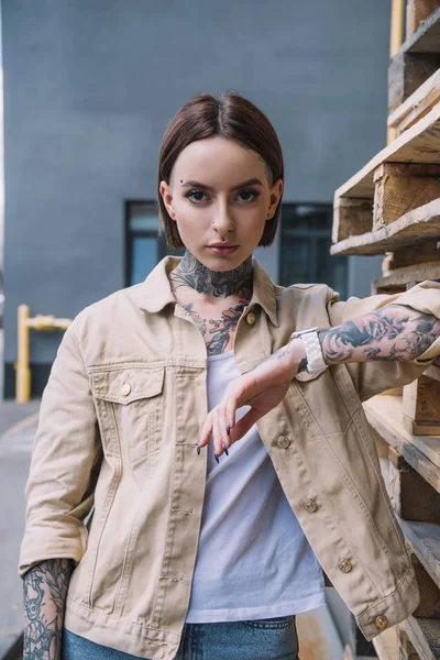 Retrato de jovem elegante mulher tatuada olhando para a câmera — Fotografia de Stock