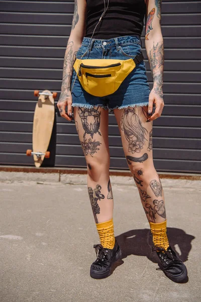 Imagem cortada de mulher tatuada elegante com saco de cintura — Fotografia de Stock