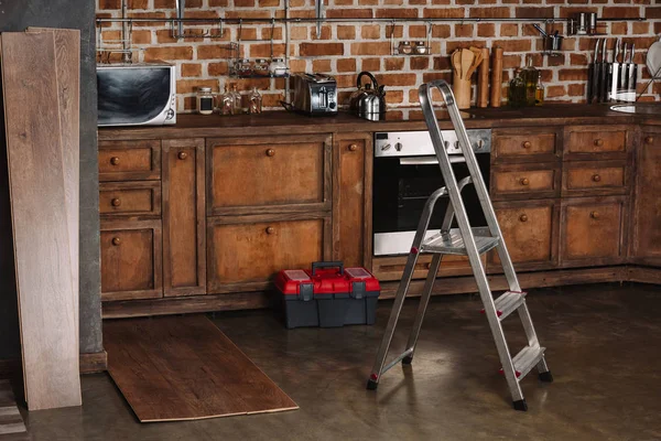Interior of loft style kitchen with stepladder, toolbox and laminate planks on floor — Stock Photo