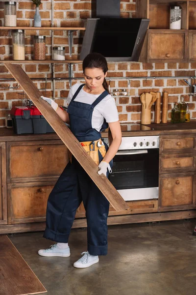 Atraente jovem reparadora instalar laminado no chão da cozinha — Fotografia de Stock