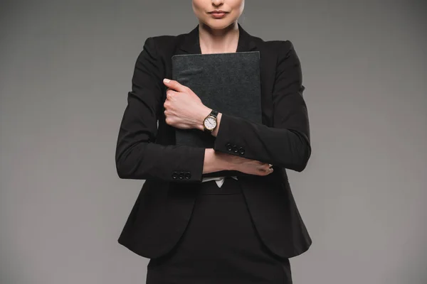 Cropped image of businesswoman holding textbook isolated on grey background — Stock Photo