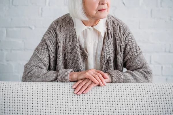 Teilansicht der Seniorin, die sich zu Hause auf Couch lehnt — Stockfoto