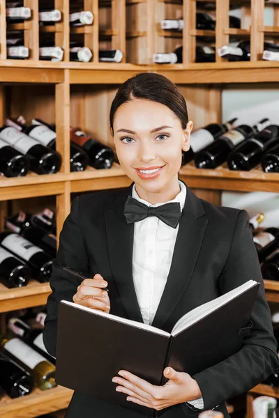 Bella steward vino femminile con notebook in enoteca — Foto stock
