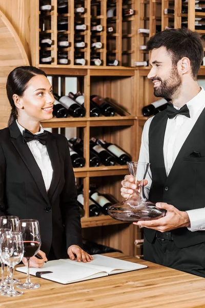 Couple de stewards de vin comptant la verrerie au magasin de vin — Photo de stock