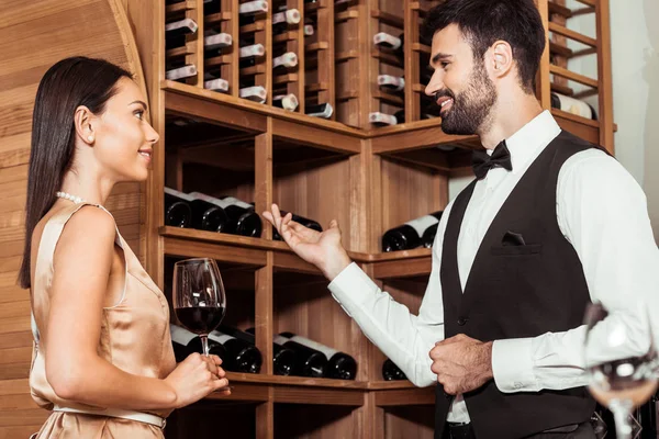 Wine steward showing wine storage to beautiful young woman — Stock Photo